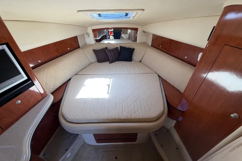 Slide: The Image of Interior cabin of 2006 Sea Ray Sundancer 320 with cozy bed and wooden accents. - 11