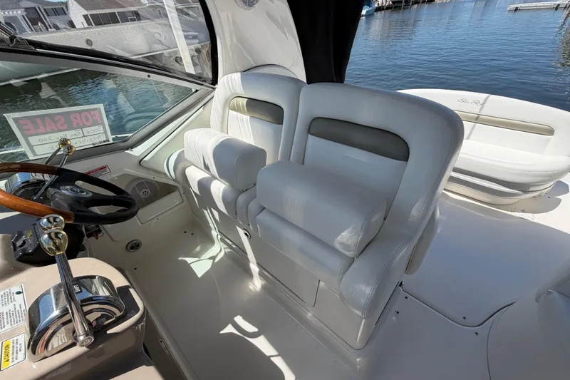 Slide: The Image of 2006 Sea Ray Sundancer 320 cockpit with white seating, steering wheel, and "For Sale" sign. - 14