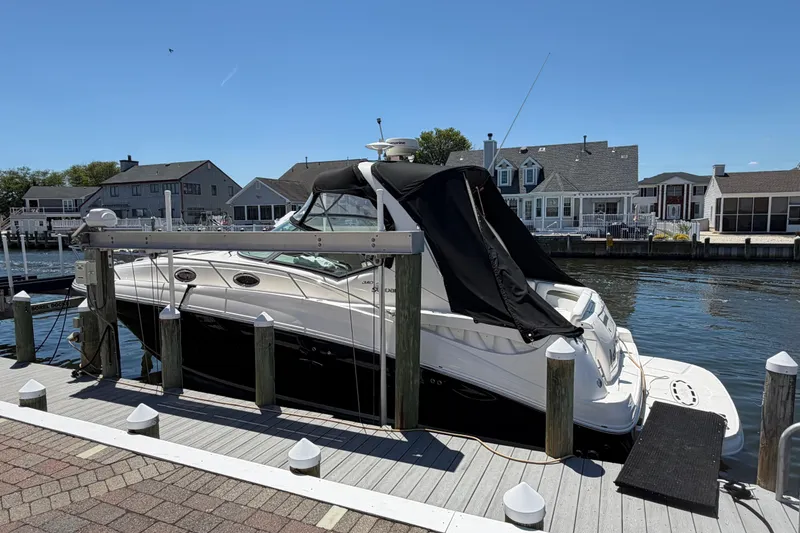 Slide: The Image of 2006 Sea Ray Sundancer 320 docked at a marina, featuring a sleek black and white design. - 2