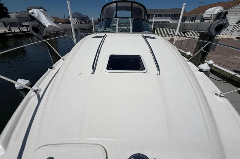 Slide: The Image of 2006 Sea Ray Sundancer 320 yacht docked, showcasing sleek deck design and waterfront setting. - 20
