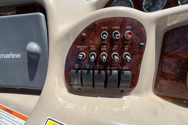 Slide: The Image of Control panel of a 2006 Sea Ray Sundancer 320 boat with various switches and dials. - 24