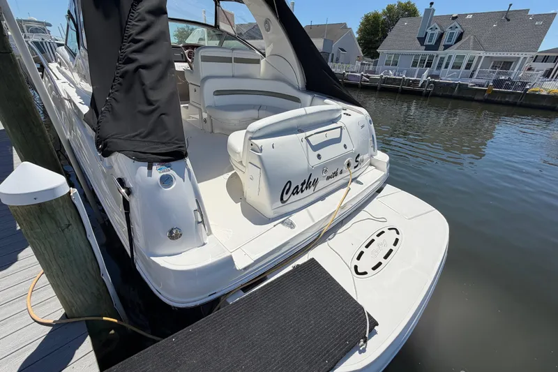 Slide: The Image of 2006 Sea Ray Sundancer 320 docked, featuring spacious seating and sleek design. - 3