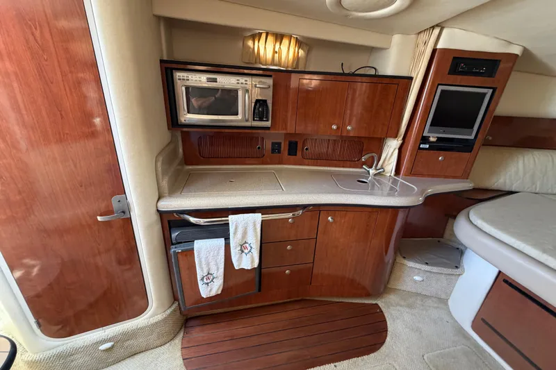 Slide: The Image of Interior of a 2006 Sea Ray Sundancer 320 yacht with kitchenette and entertainment area. - 9