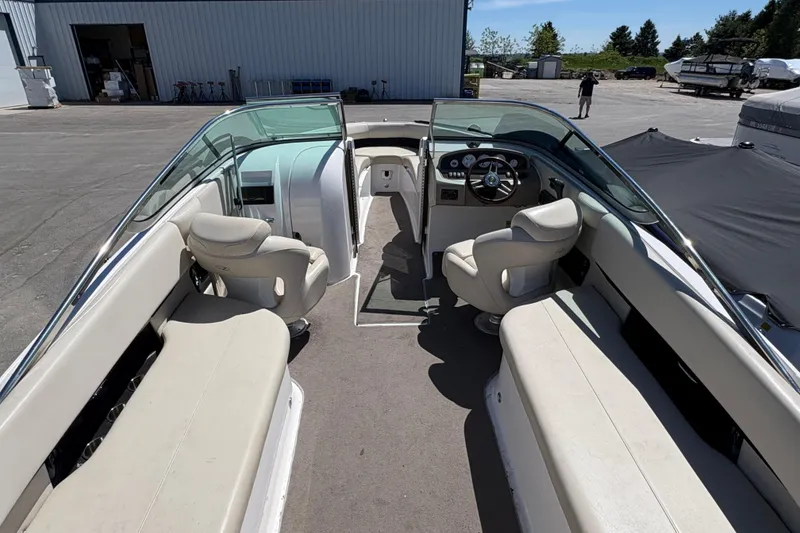 Slide: The Image of 2009 Regal 2500 Bowrider boat interior with seating and steering wheel, parked outdoors. - 19