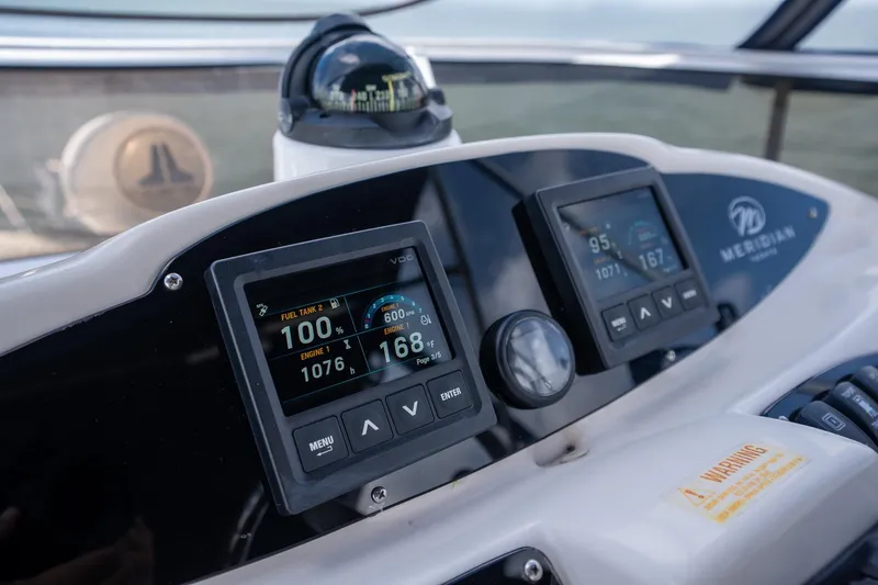 Slide: The Image of Dashboard of a 2009 Meridian 391 Sedan boat with digital displays and compass. - 25