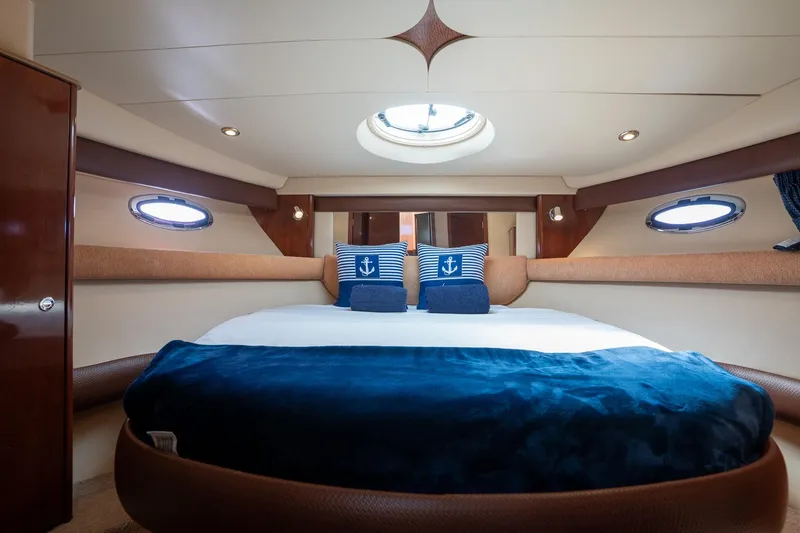 Slide: The Image of Luxurious 2009 Meridian 391 Sedan yacht bedroom with nautical-themed decor and porthole windows. - 30