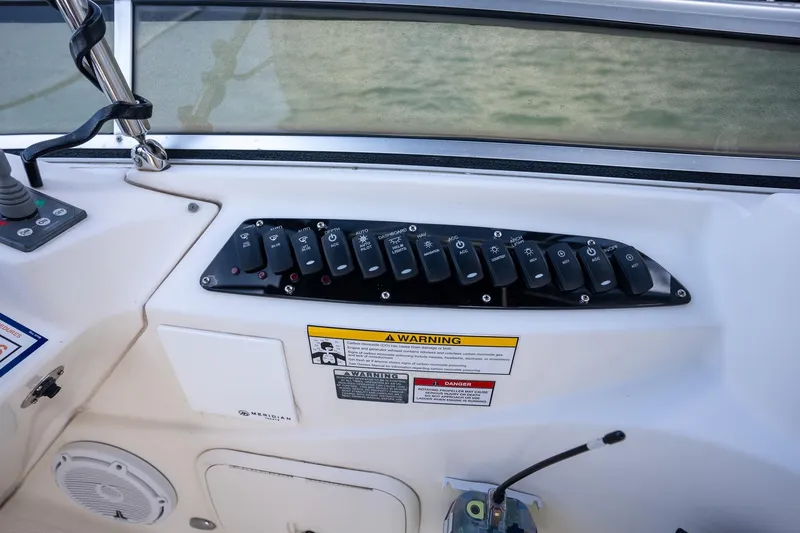 Slide: The Image of Control panel of a 2009 Meridian 391 Sedan boat with labeled switches. - 32