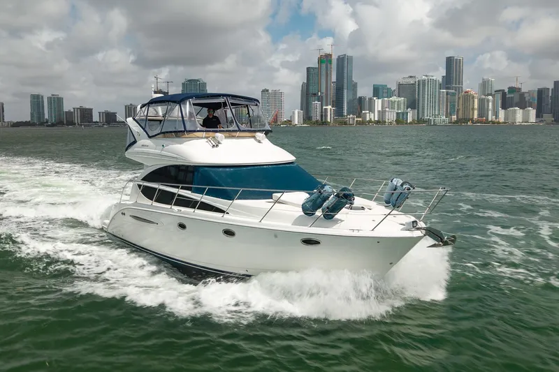 Slide: The Image of 2009 Meridian 391 Sedan yacht cruising near city skyline under cloudy skies. - 4