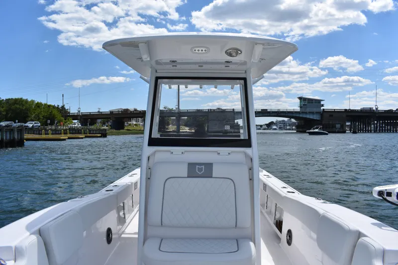 Slide: The Image of 2026 Sea Fox 248 Commander boat on water, bridge in background, clear sky. - 9