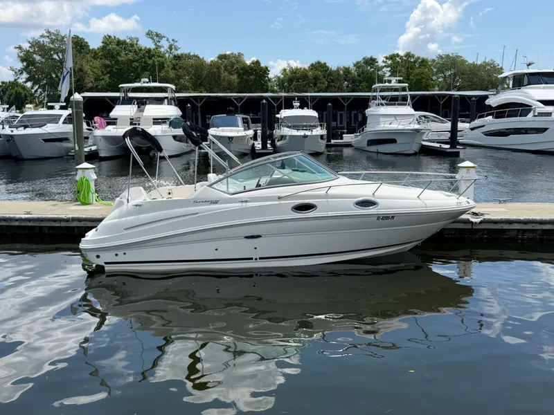 Slide: The Image of 2011 Sea Ray 240 Sundancer docked, surrounded by yachts. - 2