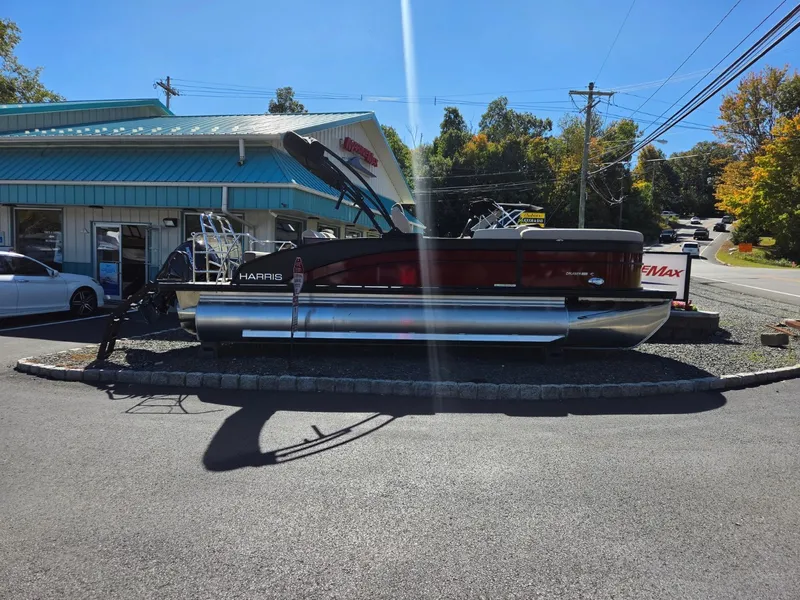 Slide: The Image of A 2027 Harris Cruiser 210 pontoon boat is parked on a lot in front of a building. - 5