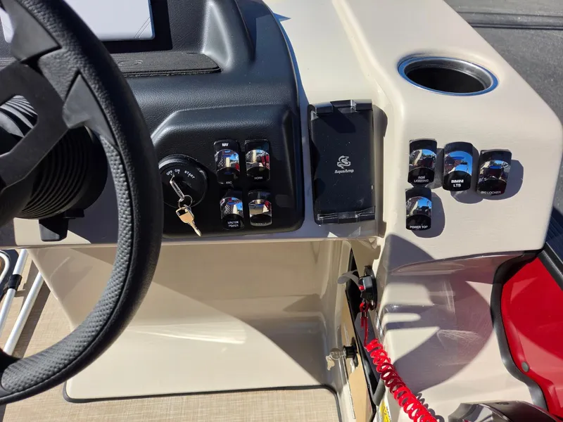 Slide: The Image of The image shows the dashboard of a 2027 Harris Cruiser 210 with various switches and a cup holder. - 15