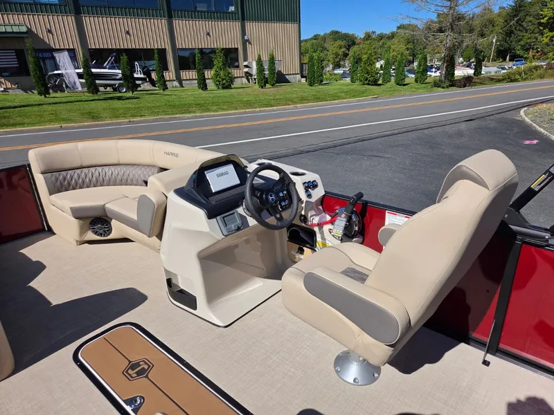 Slide: The Image of The image shows the cockpit of a 2027 Harris Cruiser 210 with beige seats and a modern helm. - 12