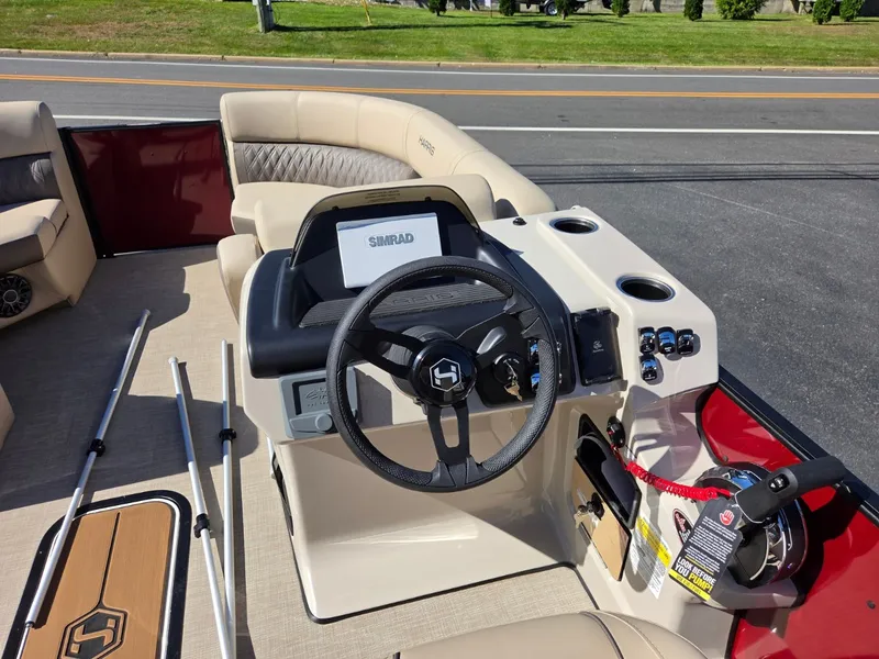 Slide: The Image of The image shows the cockpit of a 2027 Harris Cruiser 210 with a modern steering wheel and Simrad display. - 14