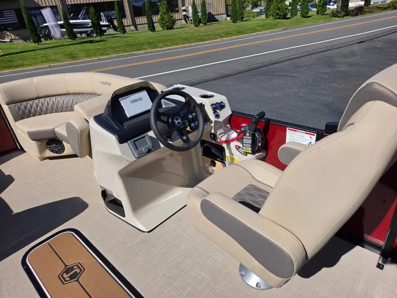 Slide: The Image of The image shows the cockpit of a 2027 Harris Cruiser 210 with beige seats and a modern helm. - 13