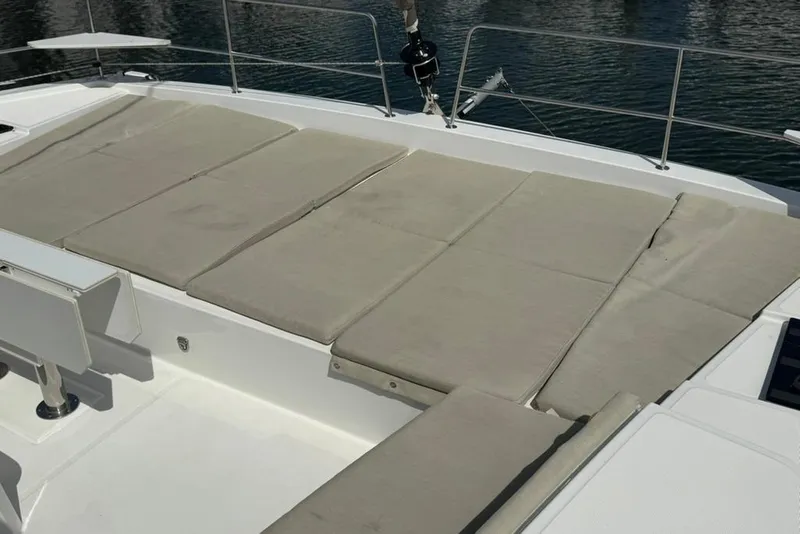 Slide: The Image of Spacious sunbathing area on 2023 Bali 4.6 catamaran, featuring comfortable beige cushions. - 16