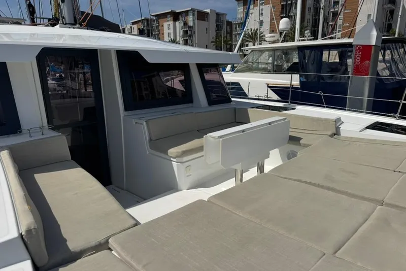 Slide: The Image of 2023 Bali 4.6 yacht with spacious deck seating in a marina setting. - 18