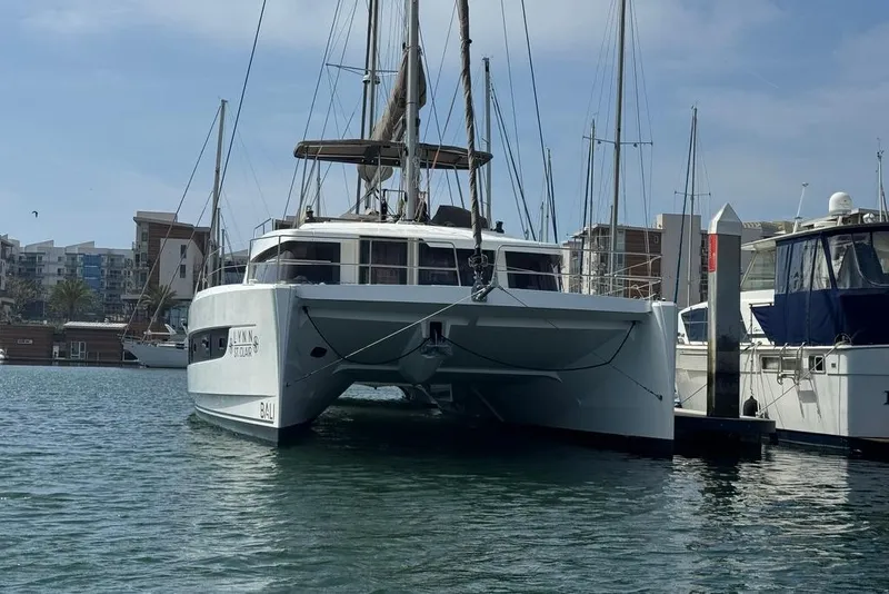 The Image of 2023 Bali 4.6 catamaran docked in a marina, surrounded by other boats. - 2