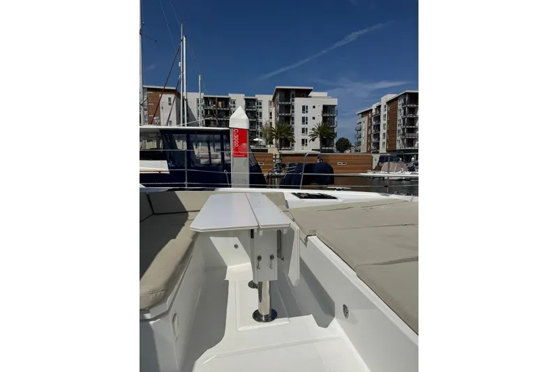 Slide: The Image of 2023 Bali 4.6 yacht interior with table, docked near modern buildings under clear sky. - 28