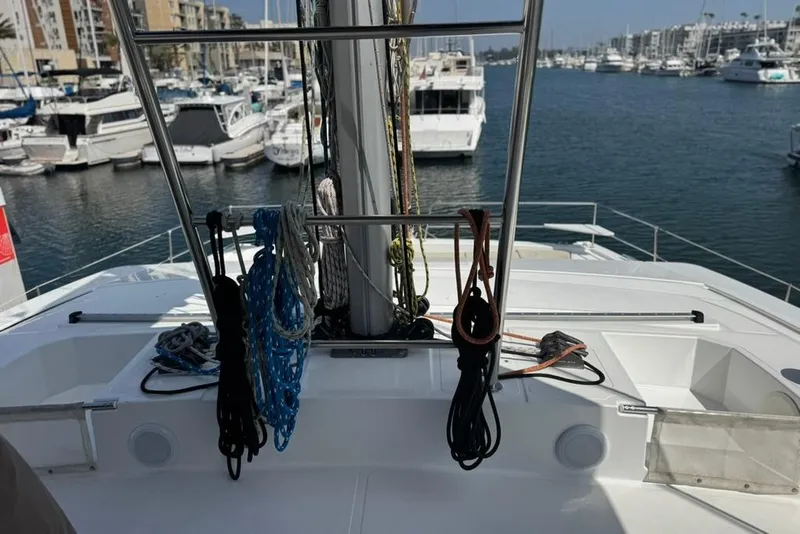 Slide: The Image of Bali 4.6 catamaran deck view in marina, 2023 model, with ropes and boats docked. - 32