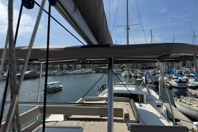 Slide: The Image of Modern Bali 4.6 catamaran docked in a marina, showcasing spacious deck and seating, 2023 model. - 35