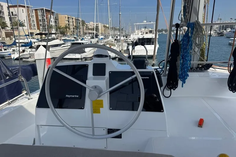 Slide: The Image of Steering wheel of 2023 Bali 4.6 yacht docked at marina with boats in background. - 37