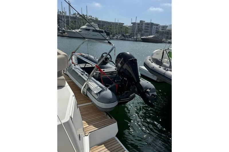 Slide: The Image of 2023 Bali 4.6 boat with motor, docked in a marina under clear skies. - 44