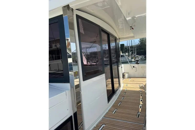 Slide: The Image of 2023 Bali 4.6 yacht with sleek design and wooden deck in marina setting. - 46