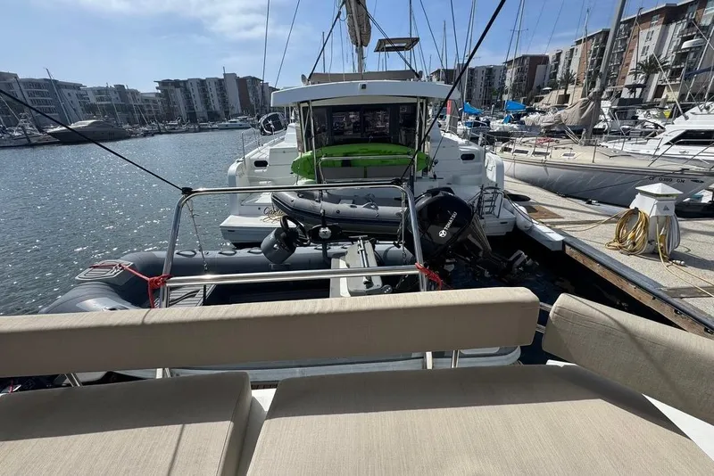 Slide: The Image of 2023 Bali 4.6 yacht docked in a marina, surrounded by other boats and waterfront buildings. - 50