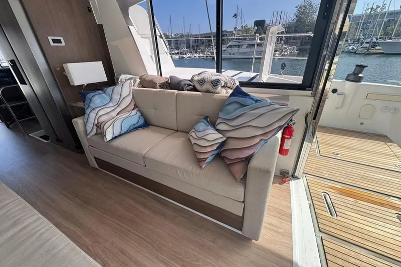 Slide: The Image of Luxurious Bali 4.6 yacht interior with plush sofa and scenic marina view, 2023 model. - 52