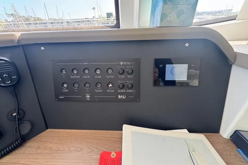 Slide: The Image of Control panel of a 2023 Bali 4.6 yacht with various switches and a digital display. - 62