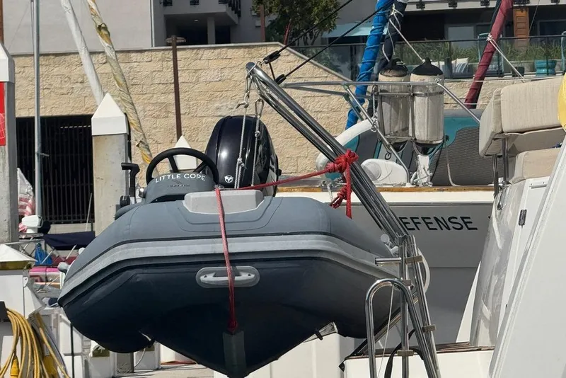 Slide: The Image of A 2023 Bali 4.6 yacht with a small dinghy attached at the stern in a marina. - 9