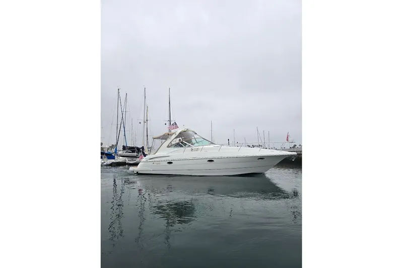 The Image of 2001 Cruisers Yachts 340 Express in marina, overcast sky, calm water. - 0