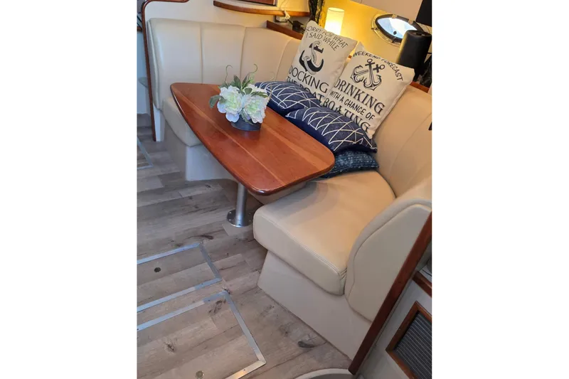 Slide: The Image of Interior of 2001 Cruisers Yachts 340 Express with cozy seating and decorative pillows. - 15