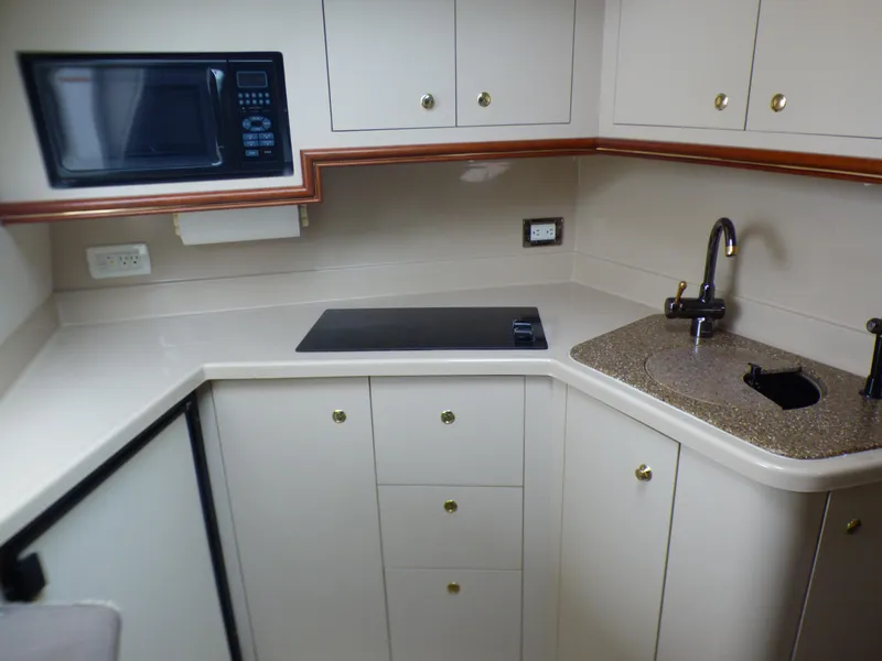 Slide: The Image of Cruisers Yachts 340 Express 2001 kitchen with microwave and sink. - 18