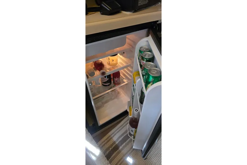 Slide: The Image of Mini fridge stocked with beverages inside a 2001 Cruisers Yachts 340 Express. - 23