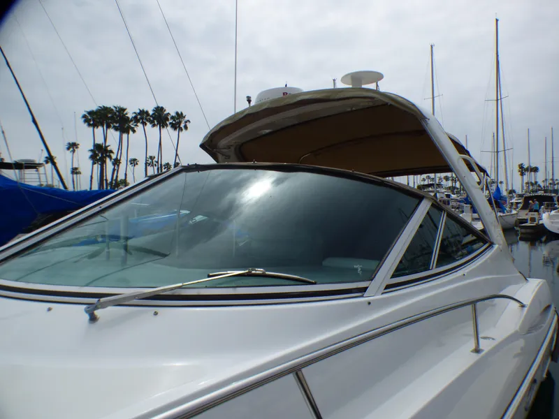 Slide: The Image of 2001 Cruisers Yachts 340 Express docked, with palm trees in the background. - 6