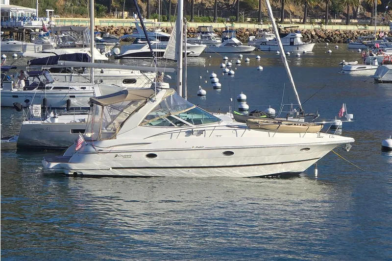 Slide: The Image of 2001 Cruisers Yachts 340 Express moored in a busy marina with other boats. - 64