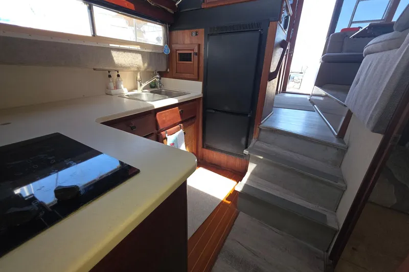 Slide: The Image of 1986 Bayliner 3888 MY Sedan interior kitchen with sink, stove, and stairs. - 19