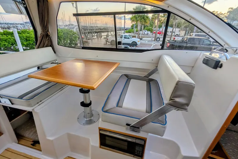 Slide: The Image of Interior of a 2017 Cutwater C-24 Coupe featuring a seating area and table. - 24