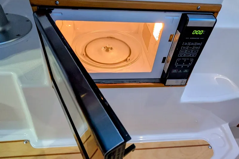 Slide: The Image of Open microwave inside a 2017 Cutwater C-24 Coupe boat kitchen area. - 27
