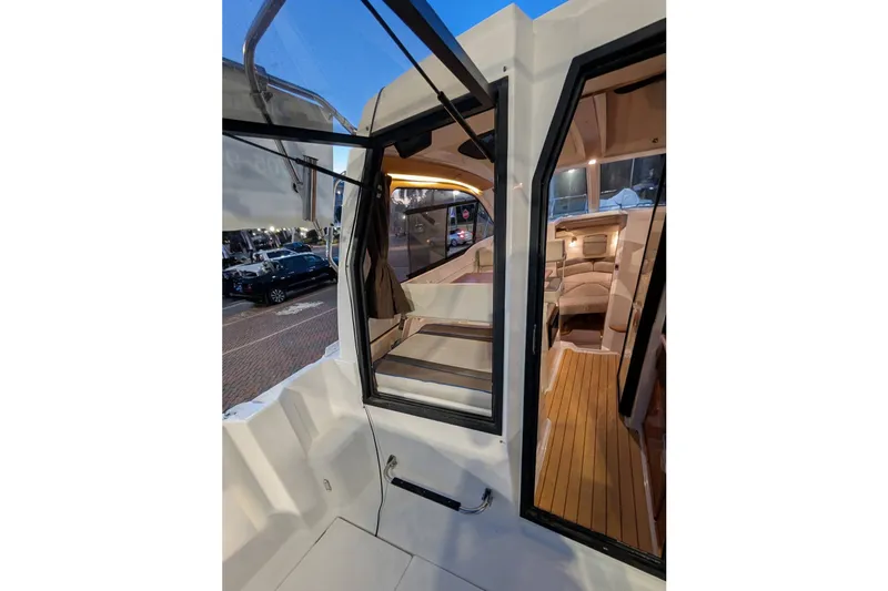 Slide: The Image of 2017 Cutwater C-24 Coupe interior view with open doors and cozy seating area. - 19