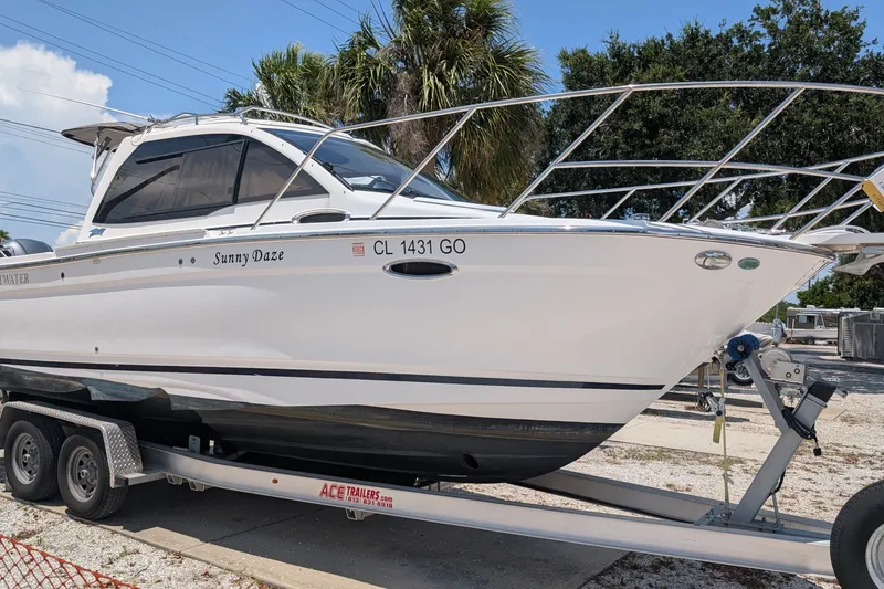 Slide: The Image of 2017 Cutwater C-24 Coupe boat on trailer, named "Sunny Daze," parked outdoors. - 1