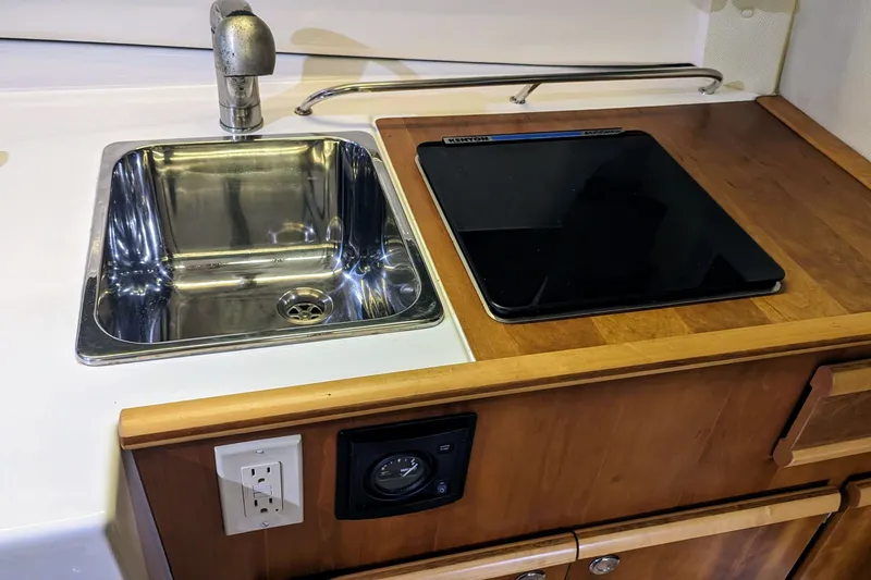Slide: The Image of 2017 Cutwater C-24 Coupe kitchen with stainless steel sink and electric cooktop. - 34