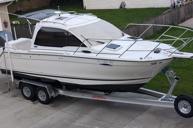 Slide: The Image of 2017 Cutwater C-24 Coupe boat on trailer in driveway, side view. - 8