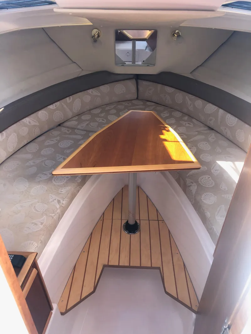 Slide: The Image of Interior of a 2017 Cutwater C-24 Coupe with a sleek wooden table and cushioned seating. - 42