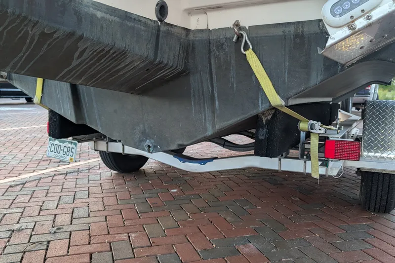Slide: The Image of 2017 Cutwater C-24 Coupe boat on trailer, secured with straps, parked on brick pavement. - 56