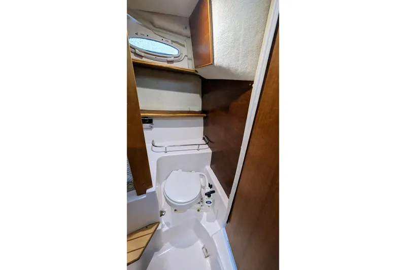 Slide: The Image of 2017 Cutwater C-24 Coupe boat interior bathroom with toilet and wooden cabinetry. - 45