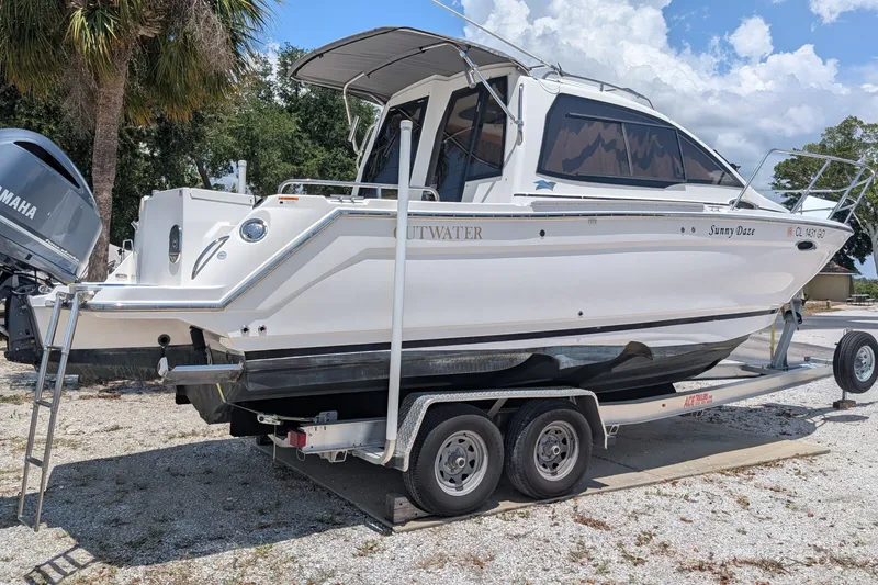 Slide: The Image of 2017 Cutwater C-24 Coupe boat on trailer, parked outdoors under a cloudy sky. - 2