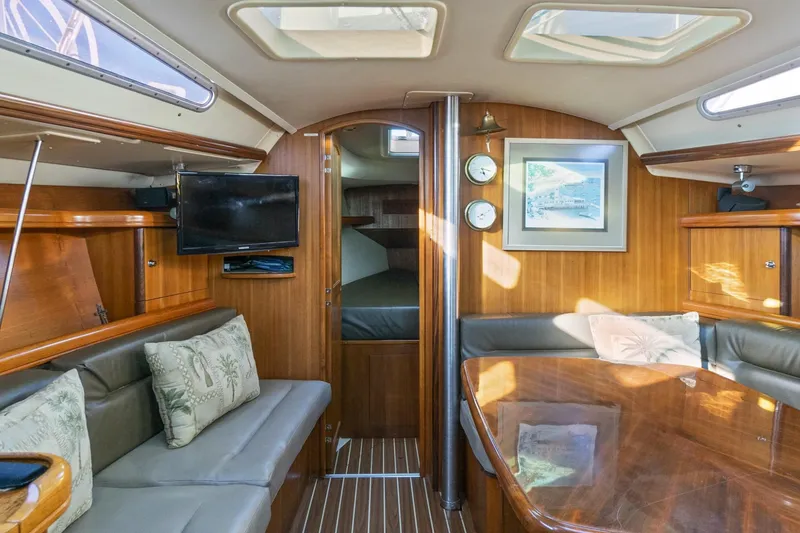 Slide: The Image of Luxurious interior of a 2006 Hunter 38 sailboat with wood paneling and seating area. - 18